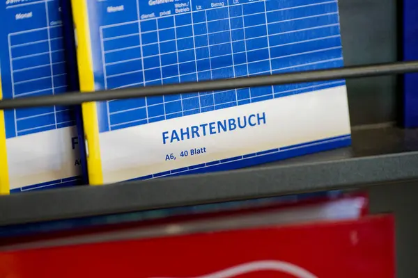 Birkaç mavi Fahrtenbuch seyahat kayıt defteri üzerinde A6 40 Blatt olarak etiketlenmiş bir siyah mağaza tezgahı satışı için düzenli olarak düzenlenmiş seyahat detayları ve mil kaydetmek için pratik bir araç sunuyor