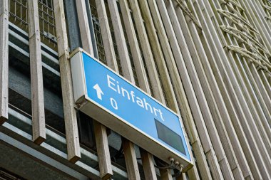 Modern bir bina cephesi dikey metal raylar kullanır. Büyük bir panoda Einfahrt girişi var, bir ok ileri ve sıfır. Katı şebeke ve endüstriyel ortam işlevsel bir şehir girişine uygun..