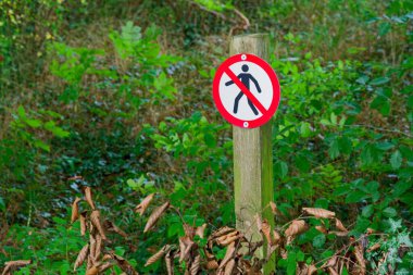 Basit bir direkte yürüyen bir figürün üzerinin çizildiğini gösteren bir tabela var. Burada geçişe izin verilmediği konusunda uyarıyorlar. Temiz grafikler ve kalın şekiller yayaları yoldan uzak tutar..