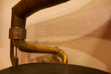 Pirinç kornanın hafif kavisli bir bölümü yumuşak ışığı yakalar. Yumuşak borular, eklemler ve tuşlar saksafon hatlarını işaret eder basit kıvrımları ve parlak lakteri sıcak bir müzik çalışmasına çevirir..