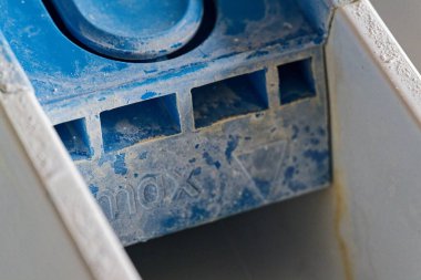 Çamaşır makinesinin deterjan çekmecesine yakın, içinde kalıntı, deterjan kalıntıları ve giysi var. Temizlik, hijyen, ev bakımı, onarım ve eşyalar için mükemmel kireç bakım temaları.