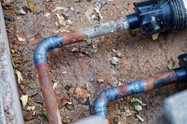 Toprak yüzeyindeki paslı bölge ısıtma borularının kapatılması. Enerji arzı, altyapı, aşınma, onarım ve ısıtma teknolojisi sembolü.