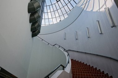 Beyaz kıvrımlı duvarlar bir dizi koyu kırmızı adımı kucaklıyor, rota nazikçe süpürüyor ve yavaş bir yürüyüşe davet ediyor, malzemeler pürüzsüz çizgiler ve sessiz denge içinde buluşuyor, özenle şekillendirilmiş sakin bir yer.