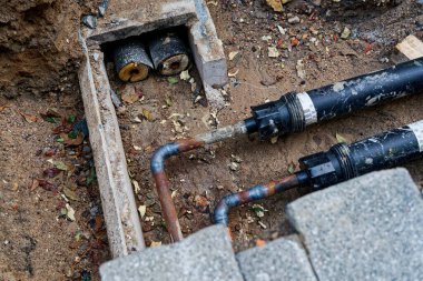 Rusty district heating pipes exposed in the ground. Concept of German energy transition, urban heating infrastructure, maintenance, and sustainable heat supply.