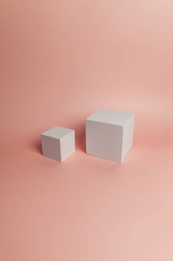 Pembe arka planda beyaz kare podyum. Kozmetik ürün sunumu için geometrik soyut şekiller. İki farklı boyutta kare şeklinde. Boşluğu kopyala.