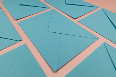 Pembe arkaplanda açık mavi zarflar. 