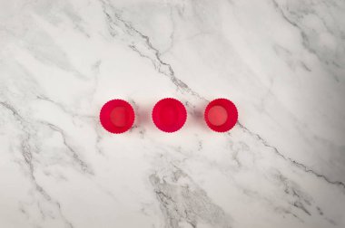 Beyaz mermer arka planda silikon kek kutularının üst görüntüsü. Çörekler ve çörekler pişirme, düzleştirme, kopyalama alanı.