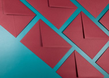 Yeşil arkaplandaki kırmızı zarfların üst görüntüsü. Düz yatay, kopyala boşluk.