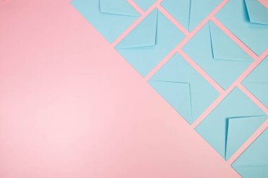 Pembe arkaplandaki açık mavi zarfların üst görüntüsü. Yat yere. Boşluğu kopyala.