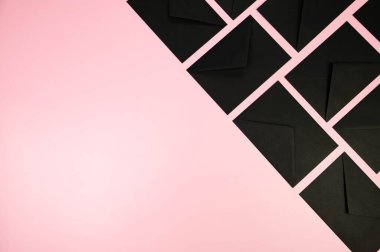 Pembe arka planda siyah zarfların üst görüntüsü. Yat yere. Boşluğu kopyala.