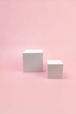 Pembe arka planda beyaz kare podyum. Kozmetik ürün sunumu için geometrik soyut şekiller. İki farklı boyutta kare şeklinde. Boşluğu kopyala.