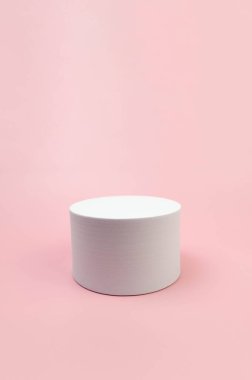 Pembe arka planda beyaz yuvarlak podyum. Kozmetik ürün sunumu için geometrik soyut şekil. Boşluğu kopyala.