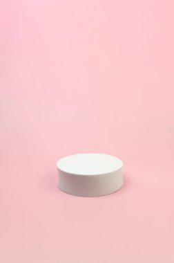 Pembe arka planda beyaz yuvarlak podyum. Kozmetik ürün sunumu için geometrik soyut şekil. Boşluğu kopyala.