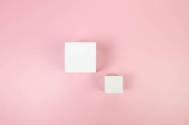 Pembe arka planda iki beyaz kare podyumun üst görüntüsü. Kozmetik ürün sunumu için geometrik soyut şekiller. Düz yat, boşluğu kopyala.