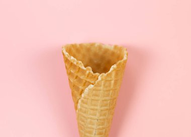 Pembe arka planda dondurmalı waffle külahının en üst görüntüsü. Yaz duvar kağıdı, düz döşeme, kopyalama alanı.