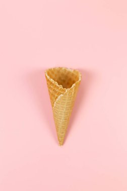 Pembe arka planda dondurmalı waffle külahının en üst görüntüsü. Yaz duvar kağıdı, düz döşeme, kopyalama alanı.
