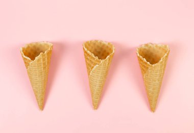 Pembe arka planda üç dondurma külahının üst görüntüsü. Yaz duvar kağıdı, düz döşeme, kopyalama alanı.