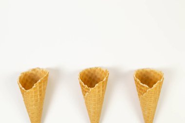 Beyaz arka planda üç dondurma külahının üst görüntüsü. Yaz duvar kağıdı, düz döşeme, kopyalama alanı.