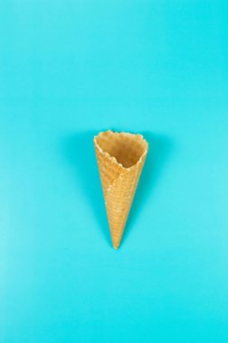 Mavi arka planda dondurmalı waffle külahının en üst görüntüsü. Yaz duvar kağıdı, düz döşeme, kopyalama alanı.