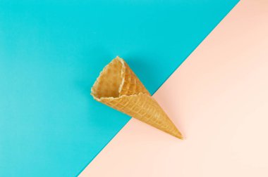 Renkli arka planda dondurmalı waffle külahının en üst görüntüsü. Yaz duvar kağıdı, düz döşeme, kopyalama alanı.