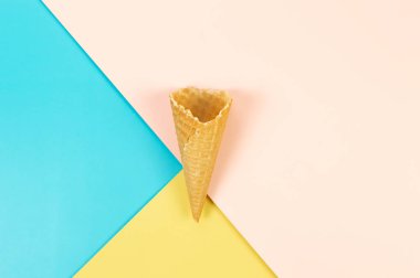 Renkli arka planda dondurmalı waffle külahının en üst görüntüsü. Yaz duvar kağıdı, düz döşeme, kopyalama alanı.