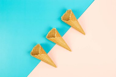 Renkli arka planda üç dondurma külahının üst görüntüsü. Yaz duvar kağıdı, düz döşeme, kopyalama alanı.