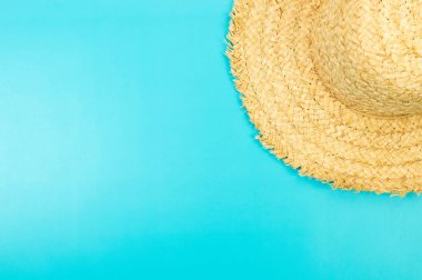 Mavi arkaplandaki hasır şapkanın üst görüntüsü. Yaz modası, tatil ve plaj duvar kâğıdı. Uzayı kopyala, düz yat.