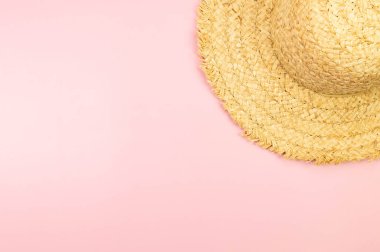 Pembe arka planda hasır şapka manzarası. Yaz modası, tatil ve plaj duvar kâğıdı. Uzayı kopyala, düz yat.