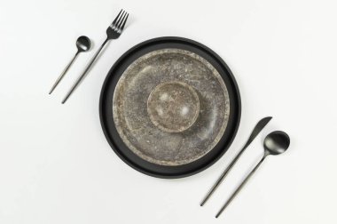 Kahverengi mermer tabak ve kâse, siyah tabak ve beyaz arka planda çatal bıçak takımı. Yemek sunumu, taş tepsi. Tablo ayarı, kopyalama alanı, düz uzanma.