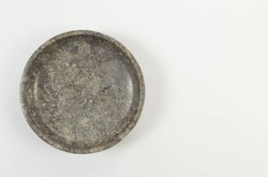 Beyaz zemin üzerinde kahverengi mermer plaka üst görünümü. Yemek sunumu, taş tepsi. Uzayı kopyala, düz yat.