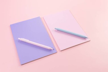 Pembe arka plandaki pembe ve mor defterlerin üst görüntüsü. Pembe ve mavi kalemler, okul, ofis kağıdı. Düz yat, boşluğu kopyala.