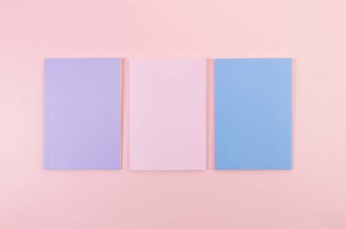 Pembe, mor ve mavi arkaplanlı defterlerin üst görüntüsü. Okul, ofis duvar kağıdı. Düz yat, boşluğu kopyala.