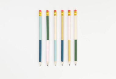 Beyaz arkaplanda renkli kalemlerin üst görünümü. Okul, ofis, duvar kâğıdı. Düz yat, boşluğu kopyala.