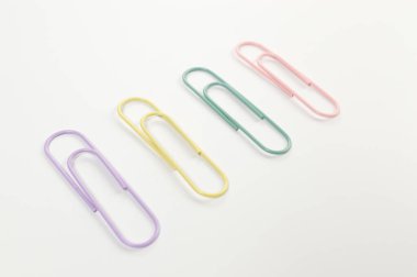 Beyaz arkaplanda renkli ataçların üst görünümü. Okul, ofis duvar kağıdı. Düz yat, boşluğu kopyala.