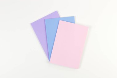 Beyaz arka planda pembe, mor ve mavi defterlerin üst görüntüsü. Okul, ofis duvar kağıdı. Düz yat, boşluğu kopyala.