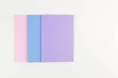 Beyaz arka planda pembe, mor ve mavi defterlerin üst görüntüsü. Okul, ofis duvar kağıdı. Düz yat, boşluğu kopyala.