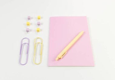 Beyaz arka planda pembe defterin üst görüntüsü. Ataç, kalem ve raptiye. Okul, ofis duvar kağıdı. Düz yat, boşluğu kopyala.