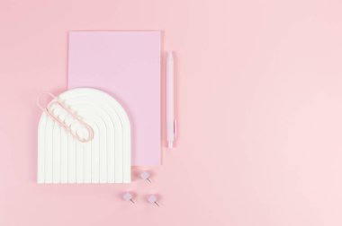 Pembe defter, pembe kalem, ataç, raptiye, pembe arka planda beyaz kemer tepsisi. Okul, ofis duvar kağıdı. Düz yat, boşluğu kopyala.
