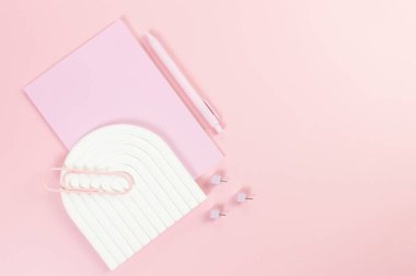 Pembe defter, pembe kalem, ataç, raptiye, pembe arka planda beyaz kemer tepsisi. Okul, ofis duvar kağıdı. Düz yat, boşluğu kopyala.
