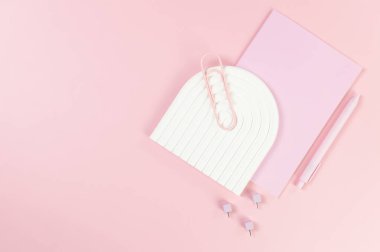 Pembe defter, pembe kalem, ataç, raptiye, pembe arka planda beyaz kemer tepsisi. Okul, ofis duvar kağıdı. Düz yat, boşluğu kopyala.