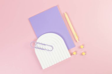 Mor defterin üst görüntüsü, sarı kalem, ataç, raptiyeler, pembe arka planda beyaz kemer tepsisi. Okul, ofis duvar kağıdı. Düz yat, boşluğu kopyala.