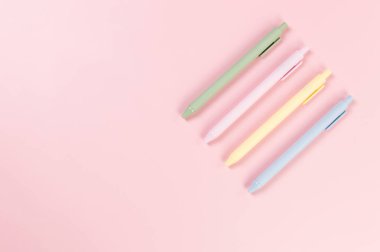 Pembe arka planda renkli kalemlerin üst görüntüsü. Okul, ofis duvar kağıdı. Düz yat, boşluğu kopyala.