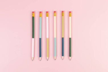 Pembe arka planda renkli kalemlerin üst görüntüsü. Okul, ofis, duvar kâğıdı. Düz yat, boşluğu kopyala.