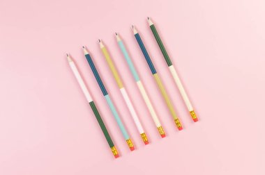 Pembe arka planda renkli kalemlerin üst görüntüsü. Okul, ofis, duvar kâğıdı. Düz yat, boşluğu kopyala.