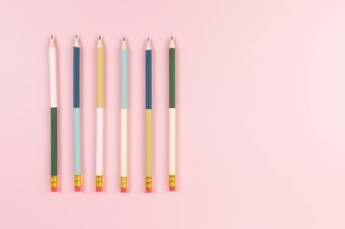 Pembe arka planda renkli kalemlerin üst görüntüsü. Okul, ofis, duvar kâğıdı. Düz yat, boşluğu kopyala.