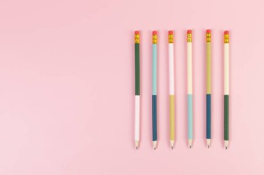 Pembe arka planda renkli kalemlerin üst görüntüsü. Okul, ofis, duvar kâğıdı. Düz yat, boşluğu kopyala.