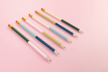 Pembe arka planda renkli kalemlerin üst görüntüsü. Okul, ofis, duvar kâğıdı. Düz yat, boşluğu kopyala.