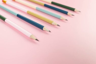 Pembe arka planda renkli kalemlerin üst görüntüsü. Okul, ofis, duvar kâğıdı. Düz yat, boşluğu kopyala.