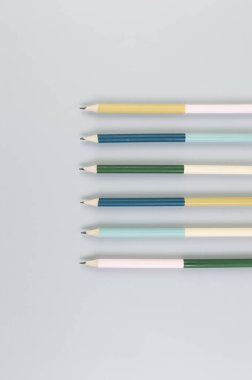 Gri arkaplanda renkli kalemlerin üst görünümü. Okul, ofis, duvar kâğıdı. Düz yat, boşluğu kopyala.