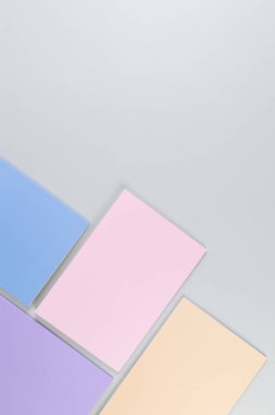 Gri arkaplanda pembe, mor, mavi ve bej renkli defterlerin üst görüntüsü. Okul, ofis duvar kağıdı. Düz yat, boşluğu kopyala.